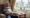 Elderly man looking out window symbolizing loneliness